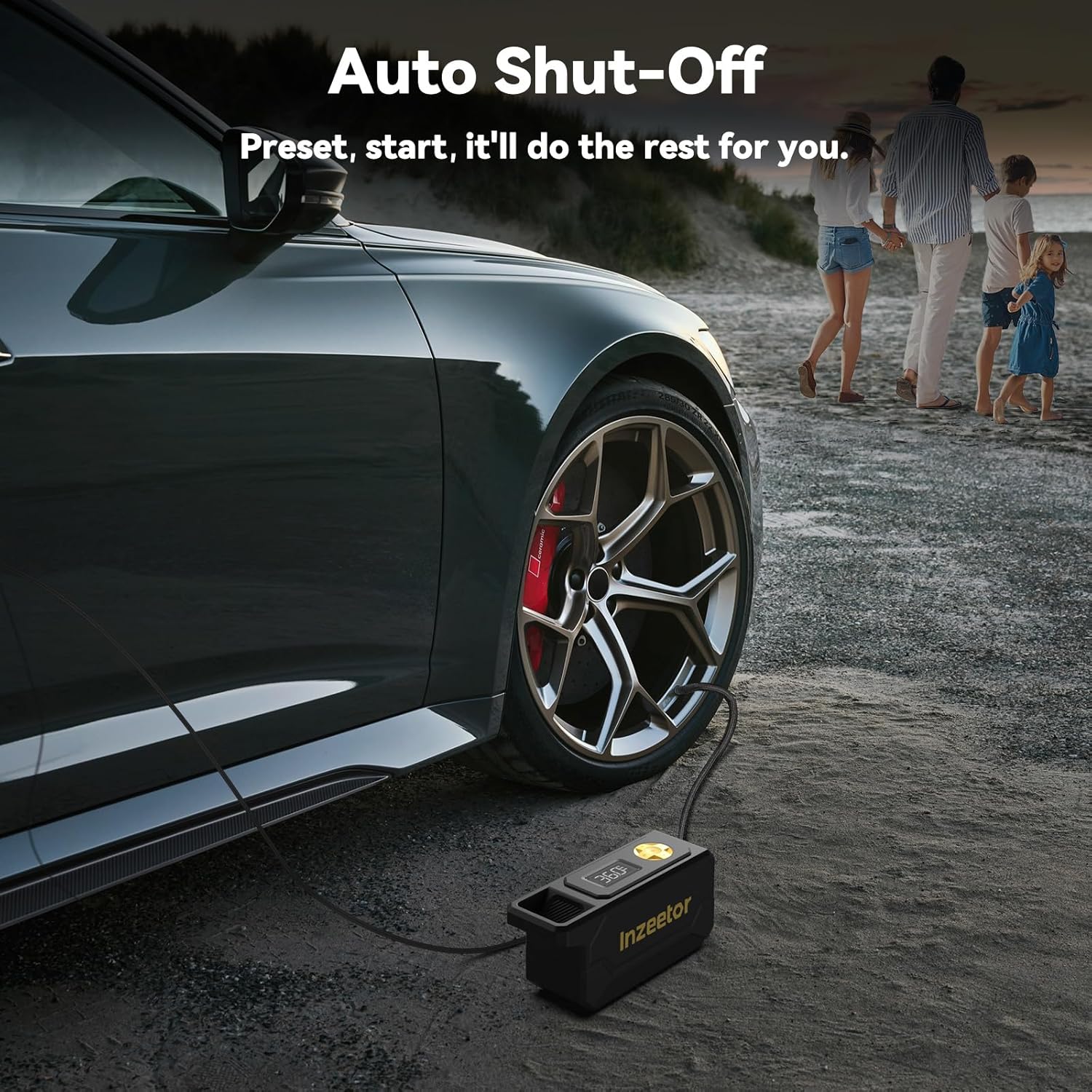 Car being pumped up with a portable air compressor on a beach, with a family in the background.