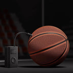 Basketball being inflated with a digital air pump on a dark background