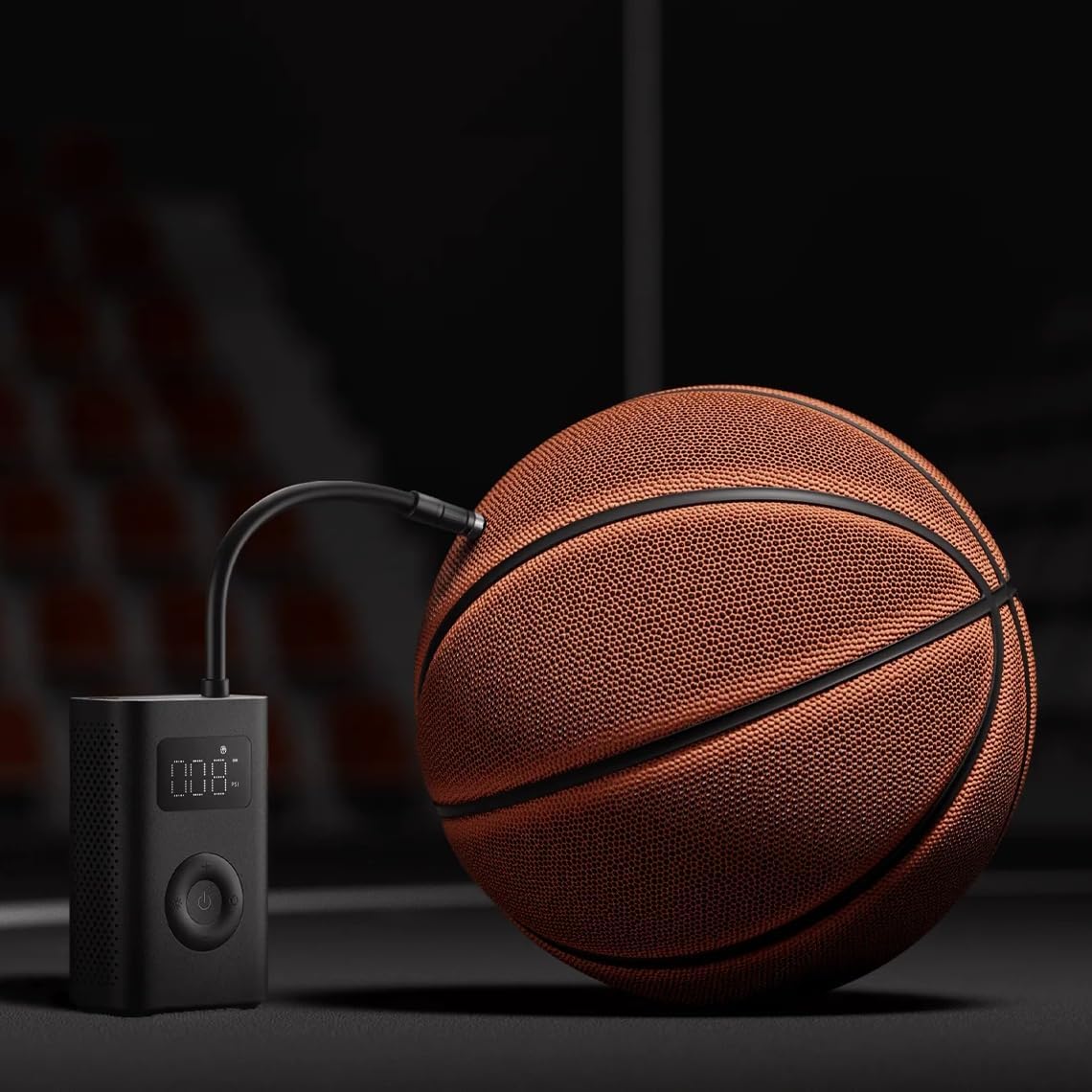Basketball being inflated with a digital air pump on a dark background