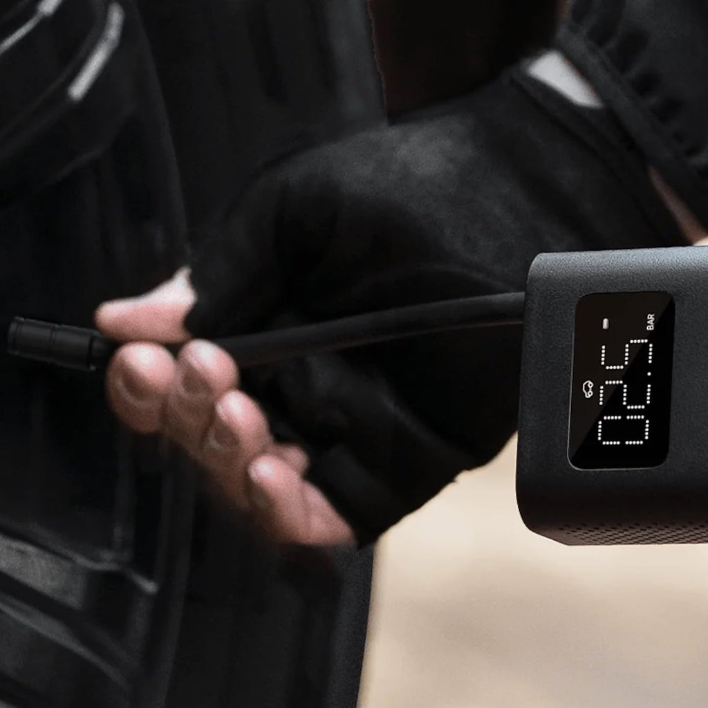 Digital tire pressure gauge being used on a car tire