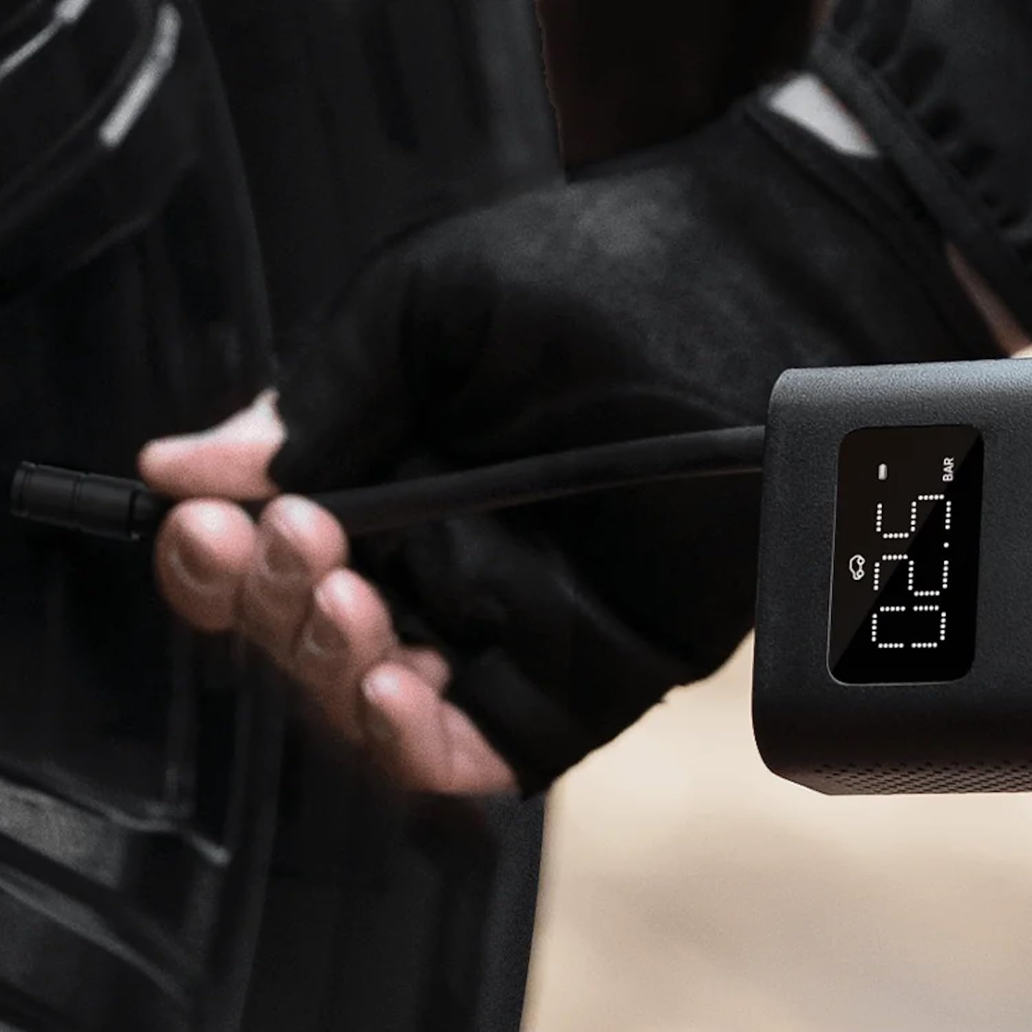 Digital tire pressure gauge being used on a car tire